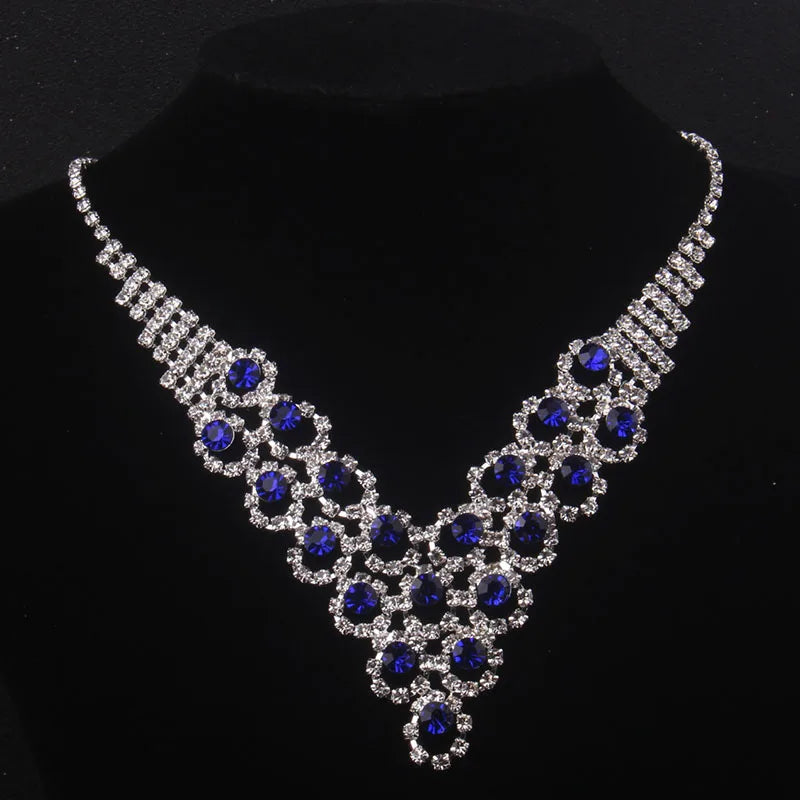 High end and elegant bridal accessories, including a necklace and a pair of earrings, set in blue, red, and purple. Bridal acces