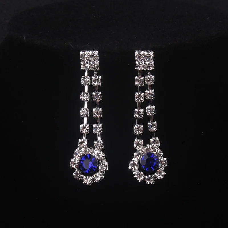 High end and elegant bridal accessories, including a necklace and a pair of earrings, set in blue, red, and purple. Bridal acces